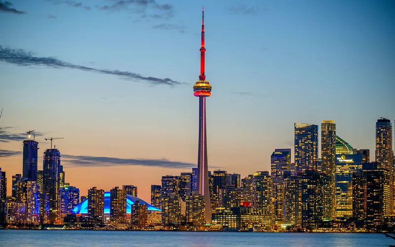 Beautiful sunset view of Toronto skyline with CN Tower and city lights reflecting on the lake