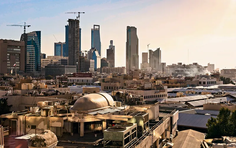 Skyline of Riyadh, Saudi Arabia featuring modern skyscrapers and construction cranes at sunset