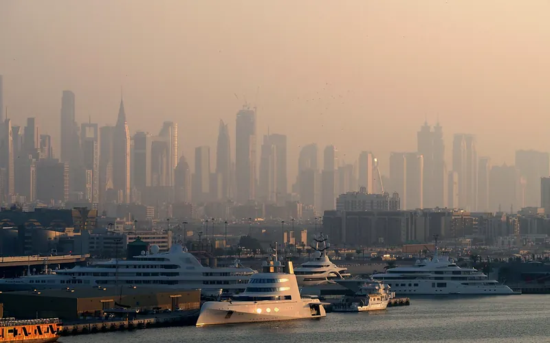 Dubai Marina with luxury yachts against a skyline of iconic skyscrapers in the morning light