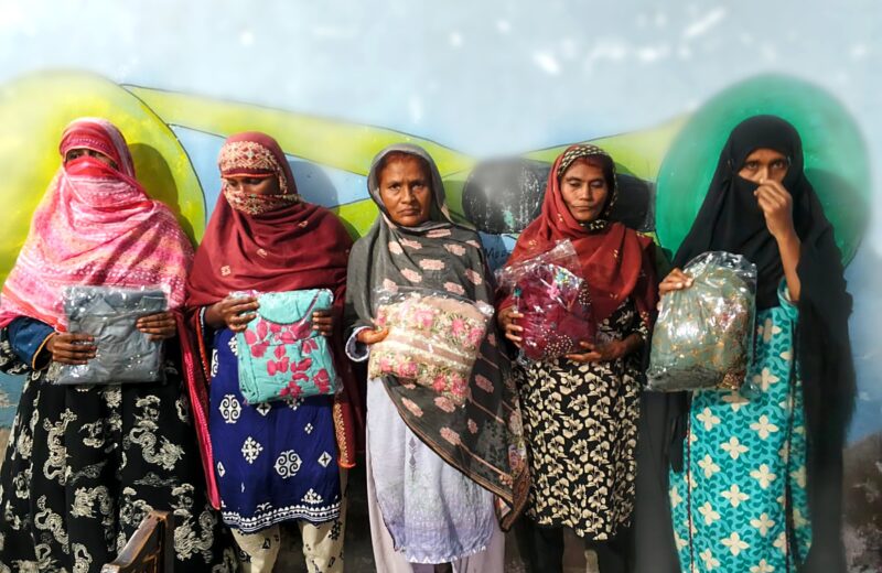 Five women in Larkana, Sindh, each holding a new packed suit received through PHWO