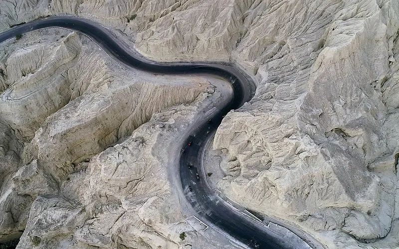 Drone shot capturing a winding road through rocky terrain in Balochistan, Pakistan, Balochistan