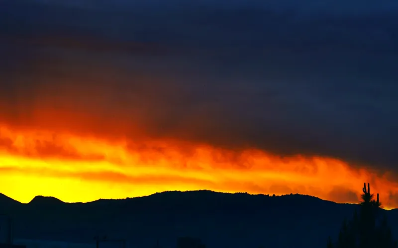 A stunning sunset in Haripur, Pakistan, with vibrant orange and dark silhouettes