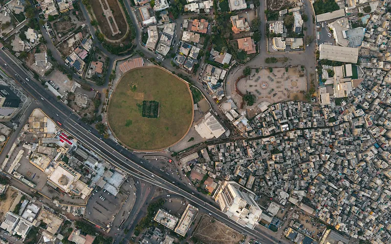 A detailed aerial shot of Karachi showing dense settlements and a distinct circular park, highlighting urban development