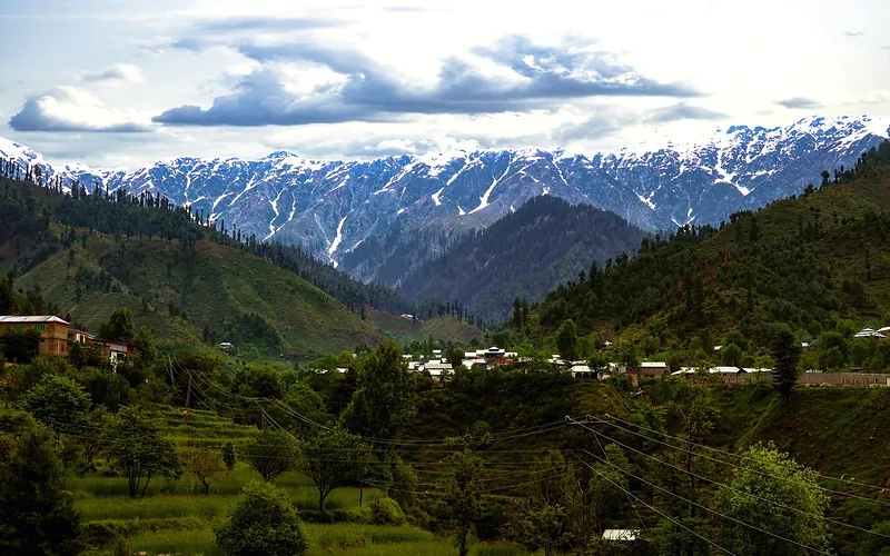 Breathtaking view of the snow-capped mountains in Swat Valley, Pakistan, under a dramatic sky